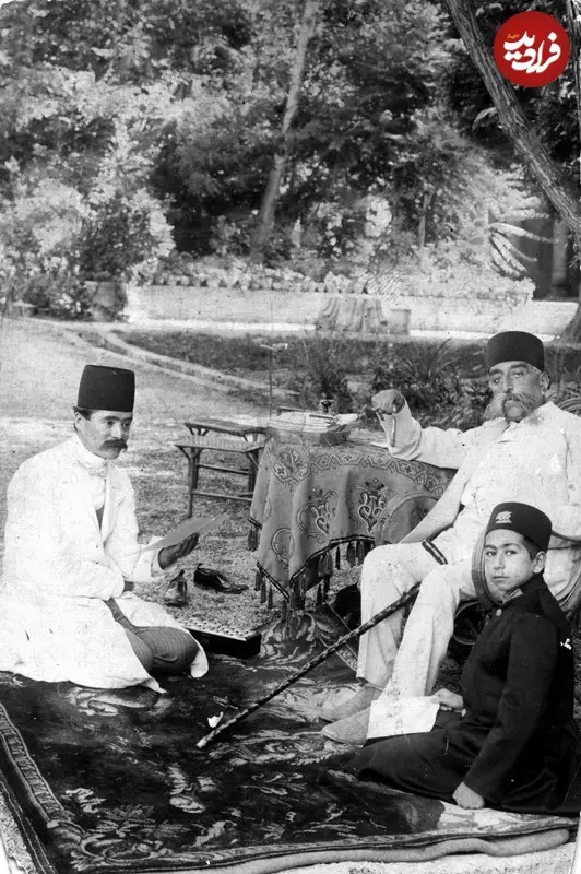 مظفرالدین شاه قاجار و یکی از شاهزاده‌ها را به همراه یکی از درباریان در حیاط کاخ صاحبقرانیه